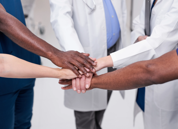 Group of diverse medical professionals putting their hands out