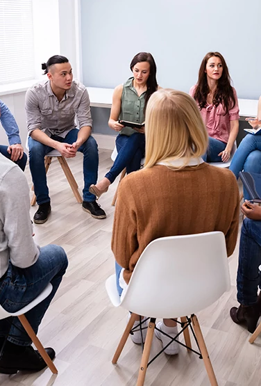Young Multiracial Millennial Friends Sitting In Circle Having Group Discussion